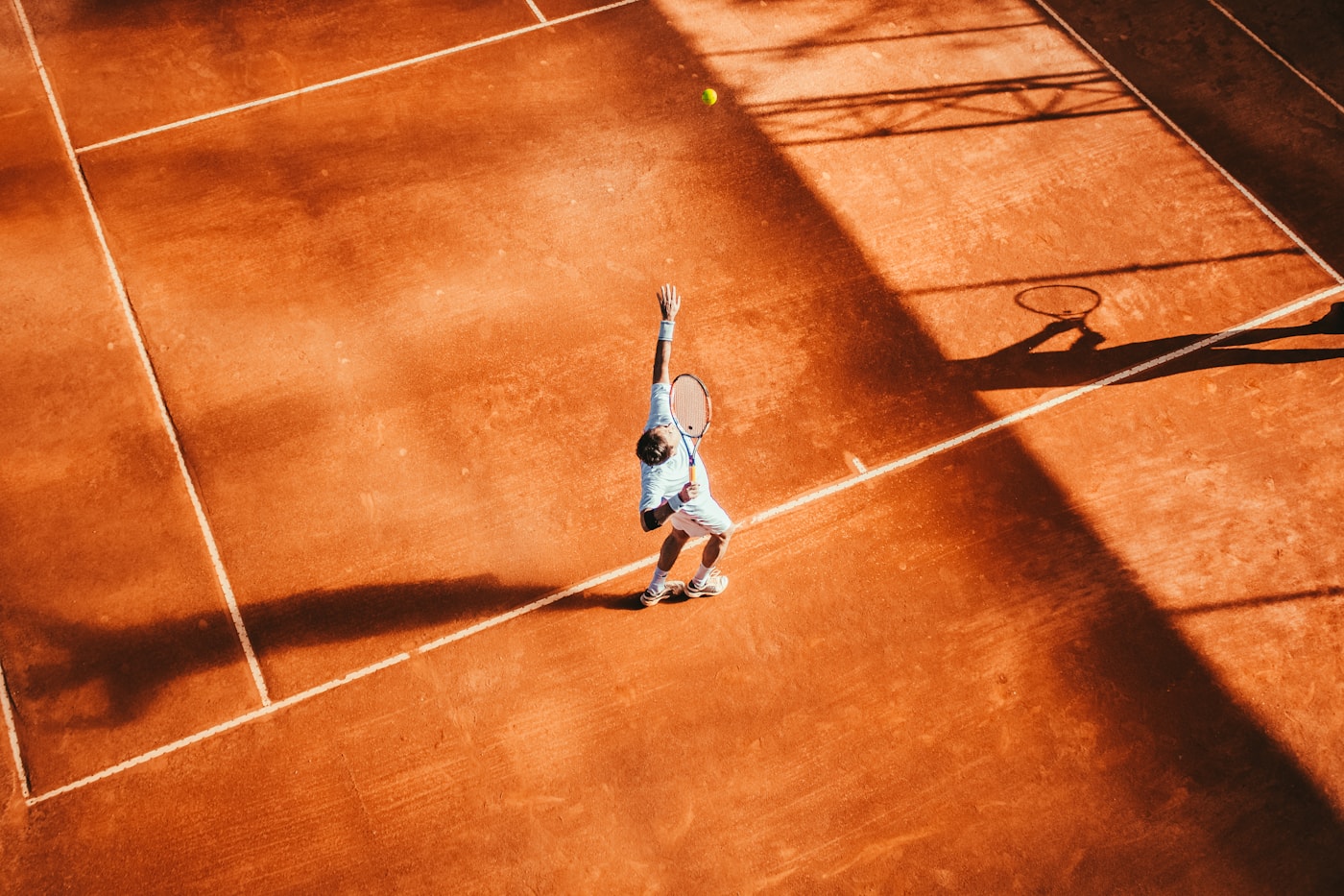Toprak kortta tenis oynayan sporcu